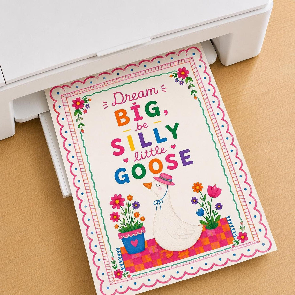 Illustrated goose wall art print emerging from a white printer on a wooden surface.