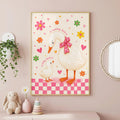 Framed wall art of a large duck and a baby duck in a pink-bordered room with hanging plants and toys.