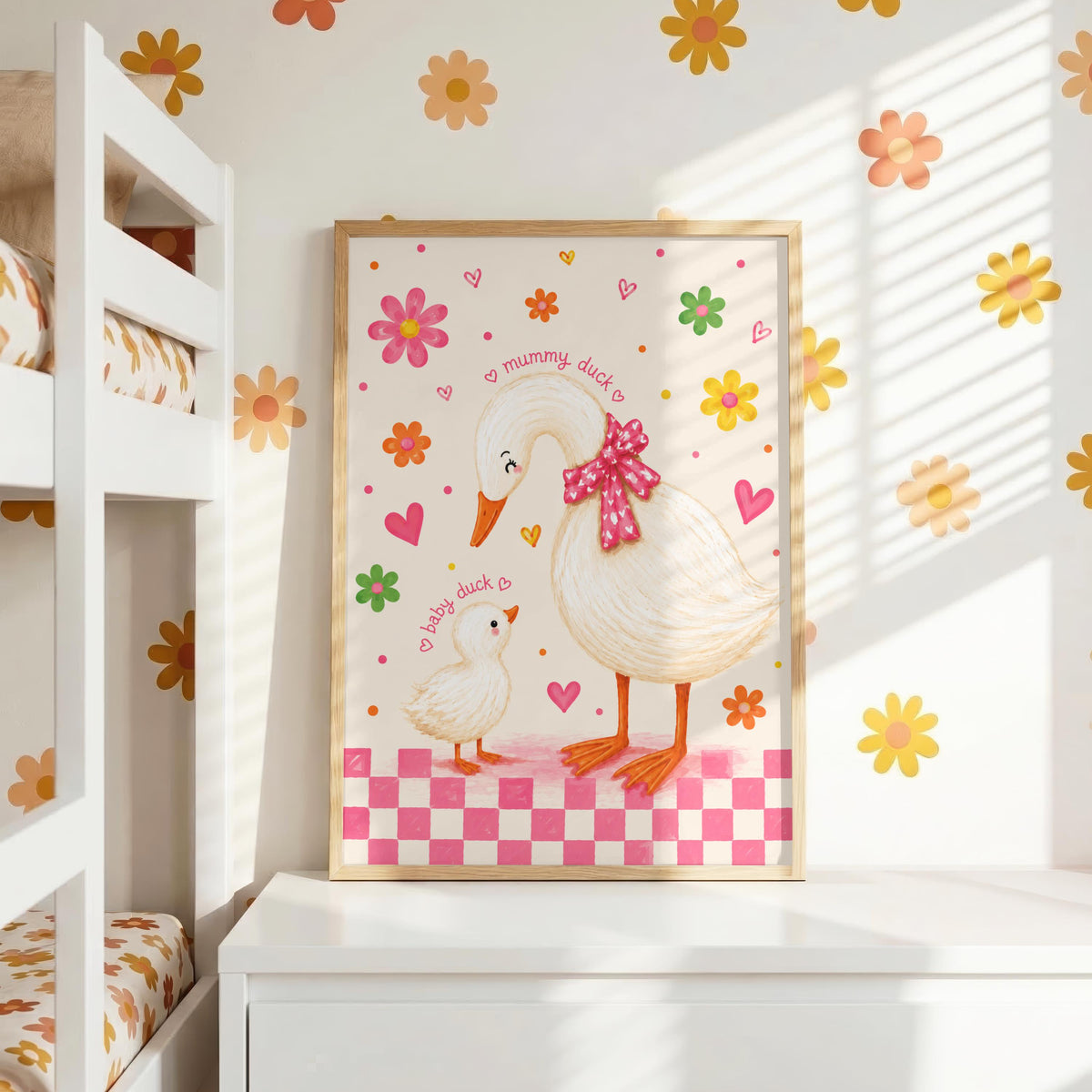 Framed duck nursery print resting on a white dresser against a wall with yellow and orange flower decals.