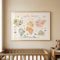 A framed pastel world map with illustrated animals hangs on a beige wall above a wooden crib and a teddy bear.