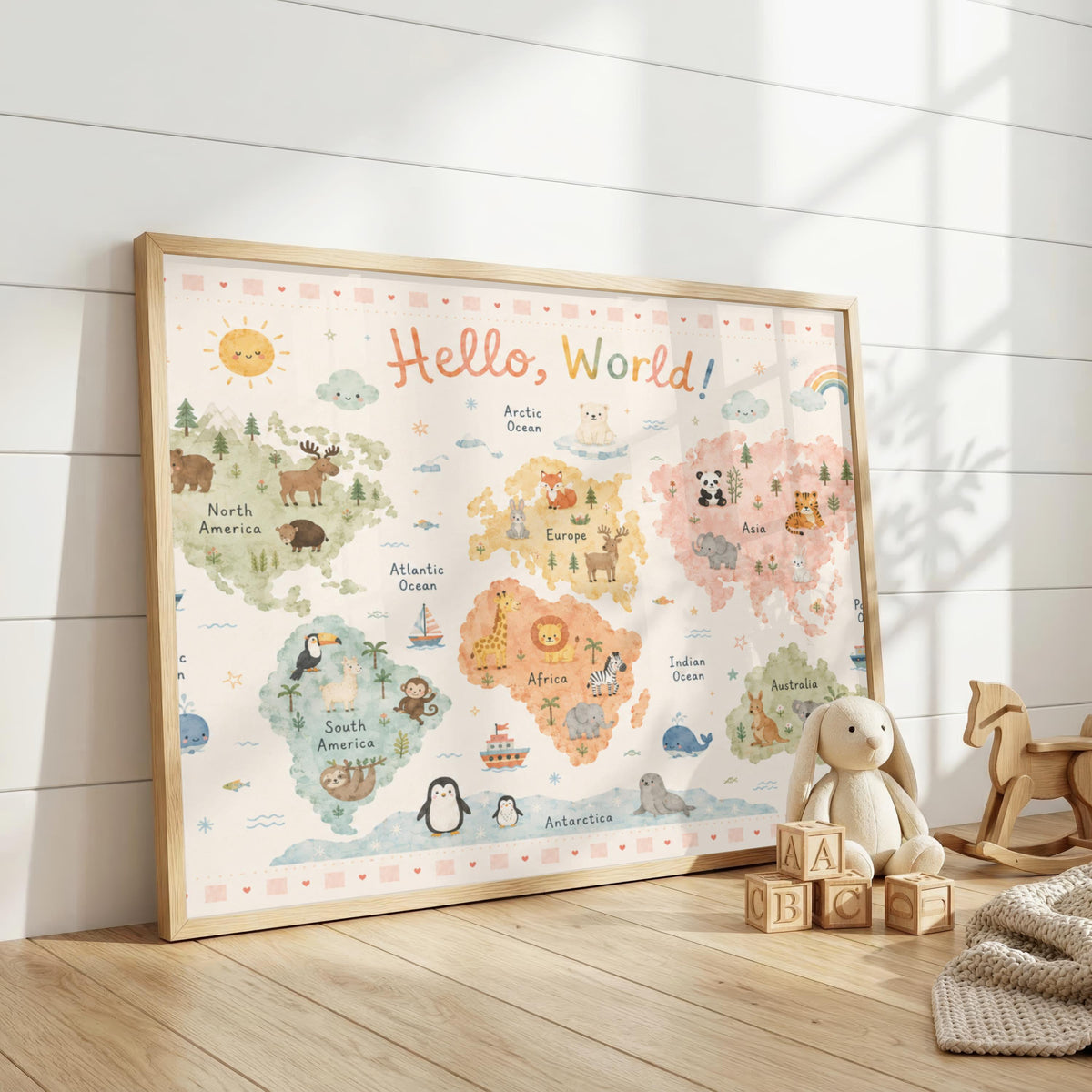 A framed pastel world map with animal illustrations leans against a white wood-paneled wall next to a stuffed toy and wooden blocks.