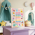 The kids affirmation framed print stands on a purple dresser next to a woven basket in a child's bedroom.