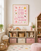 Pink children’s affirmation wall print in a light wood frame, styled in a pastel nursery playroom with wooden toy storage, teddy bear, books, rainbow toy, soft pink decor and neutral children’s room accessories.