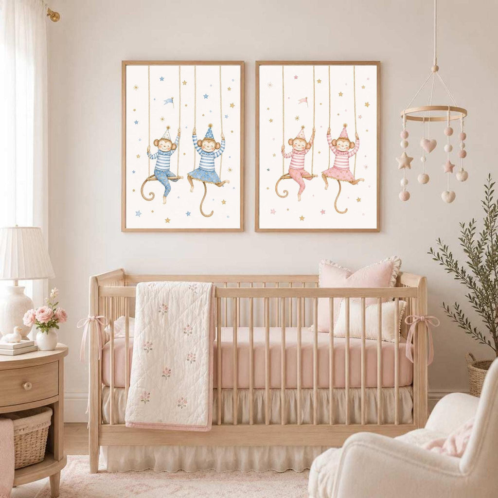 Two framed watercolor prints of monkeys on swings hang on a wall above a wooden baby crib.