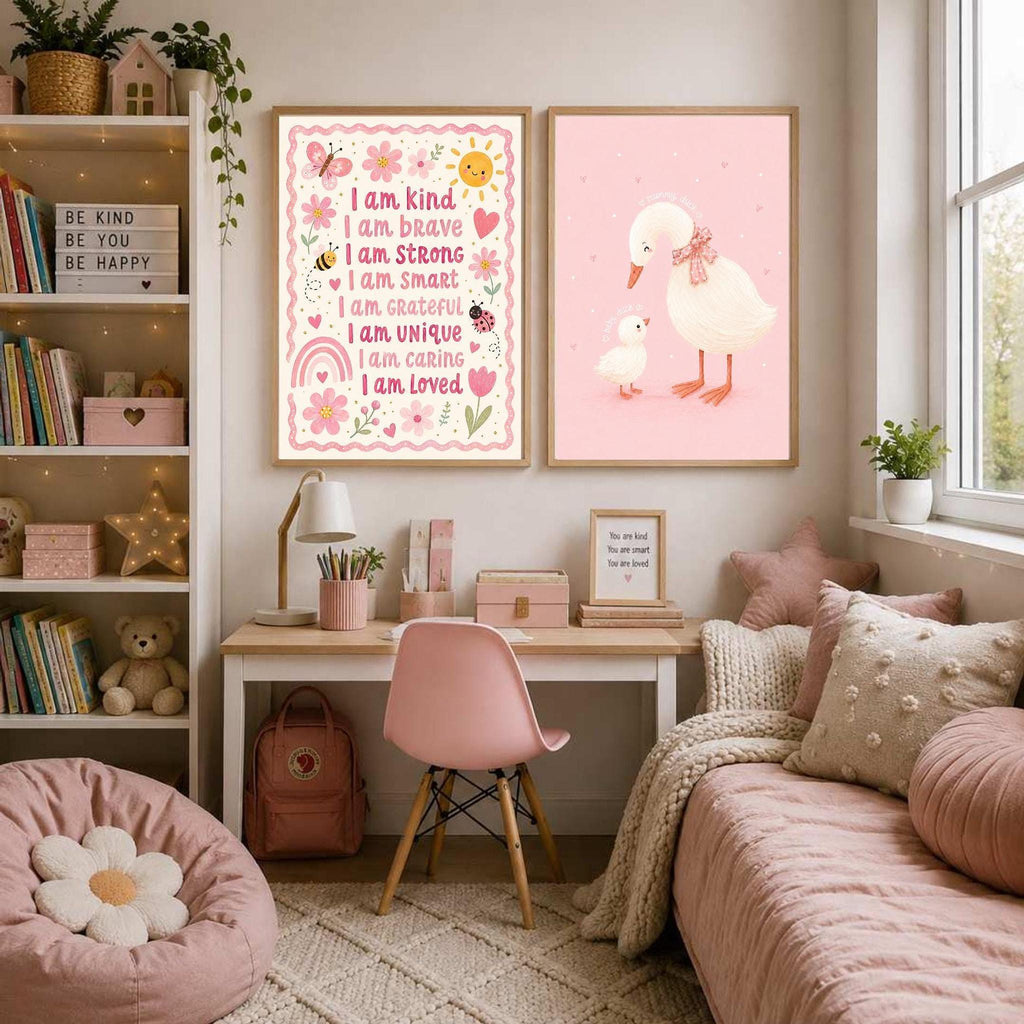 Child bedroom interior with a framed pink duck art print and a text print on the wall, pink bedding, and a pink chair.