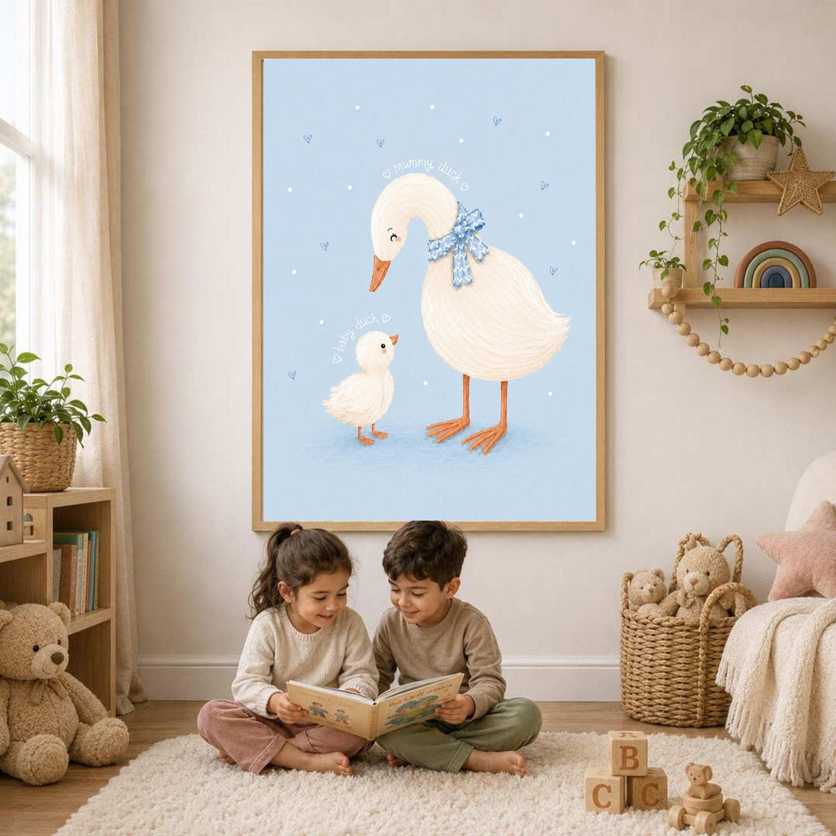 Two young children sit on a rug reading a book in front of a framed duck print and a shelf of toys.