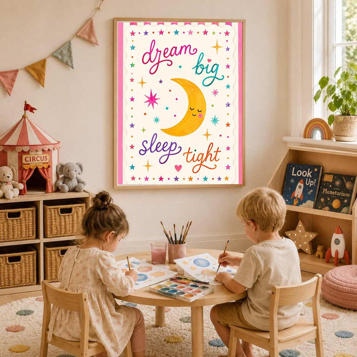 A framed poster featuring a smiling moon and the text dream big sleep tight is displayed on a white wall above a toy storage unit in a vibrant playroom with children furniture.