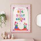 Framed wall art print of a goose wearing a pink hat with text reading Dream BIG be SILLY little GOOSE hanging on a pink wall.