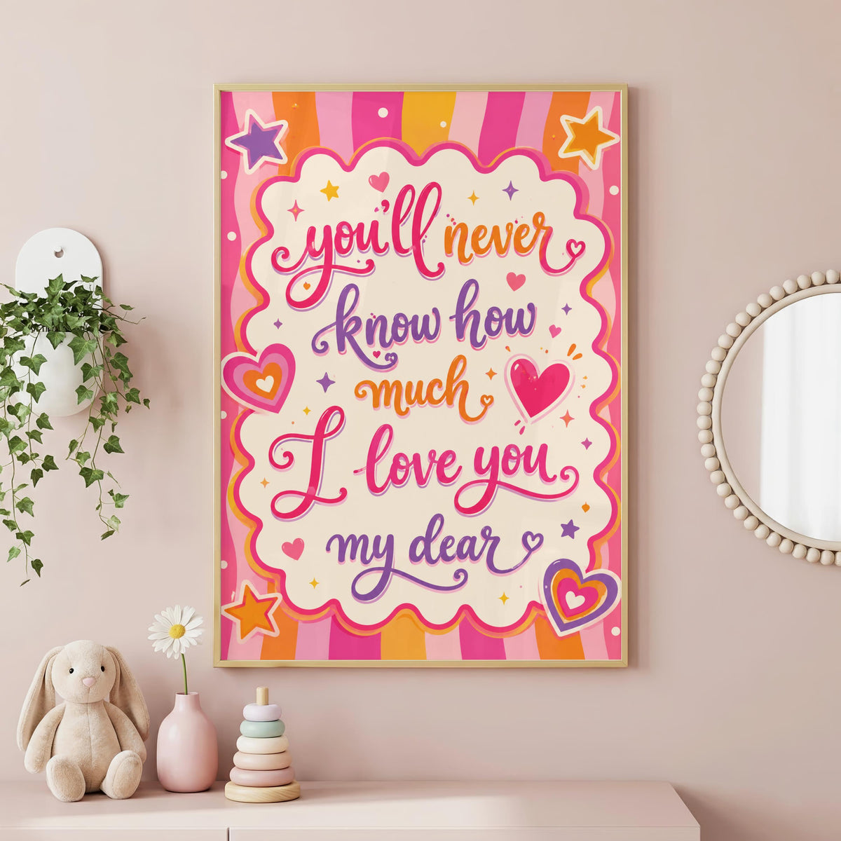 A framed colorful poster featuring the text You'll never know how much I love you my dear, hanging on a pink wall above toys and a plant.
