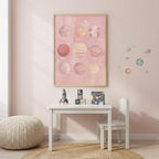 Pink solar system print hanging in a cozy pastel playroom above a children's table.