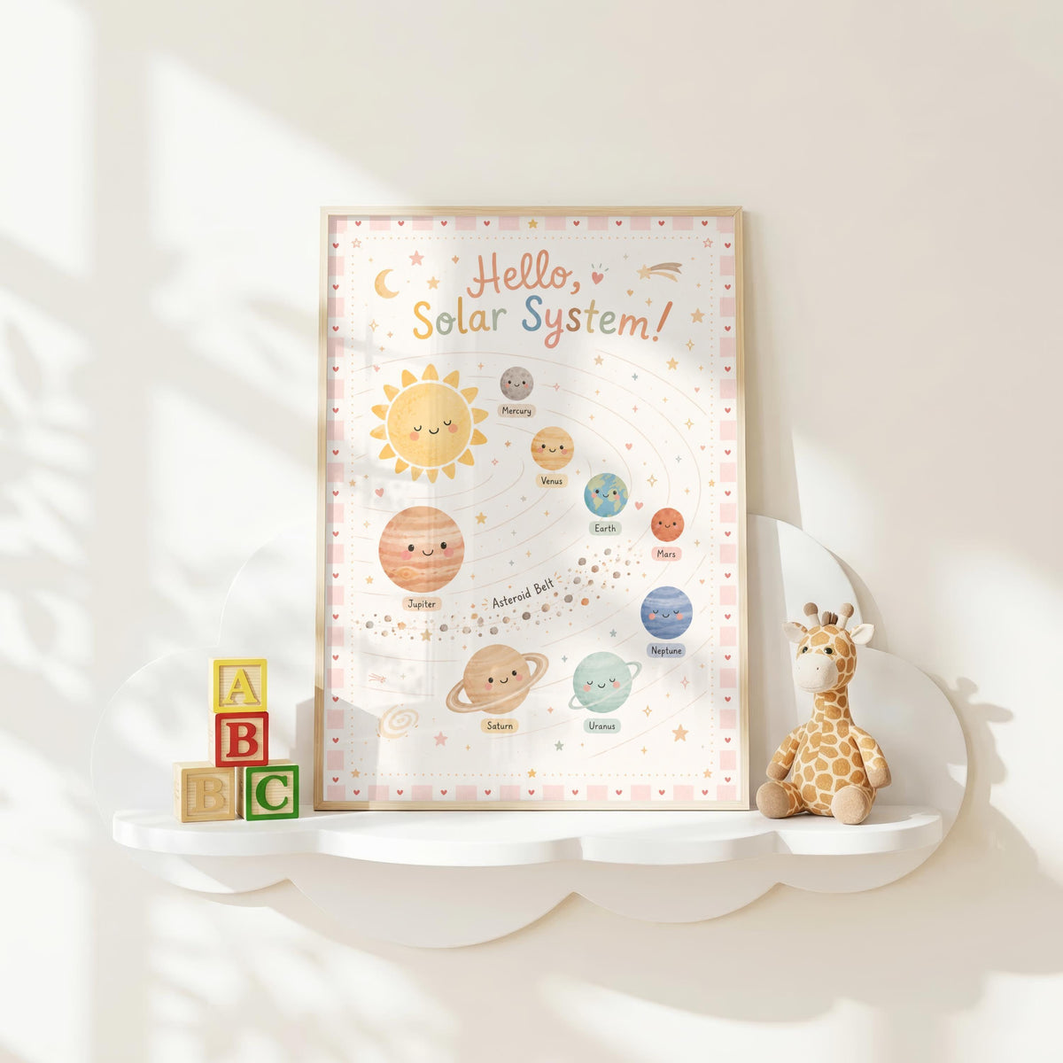 A framed pastel solar system poster sits on a white cloud-shaped shelf alongside stacked ABC blocks and a small giraffe plush toy.