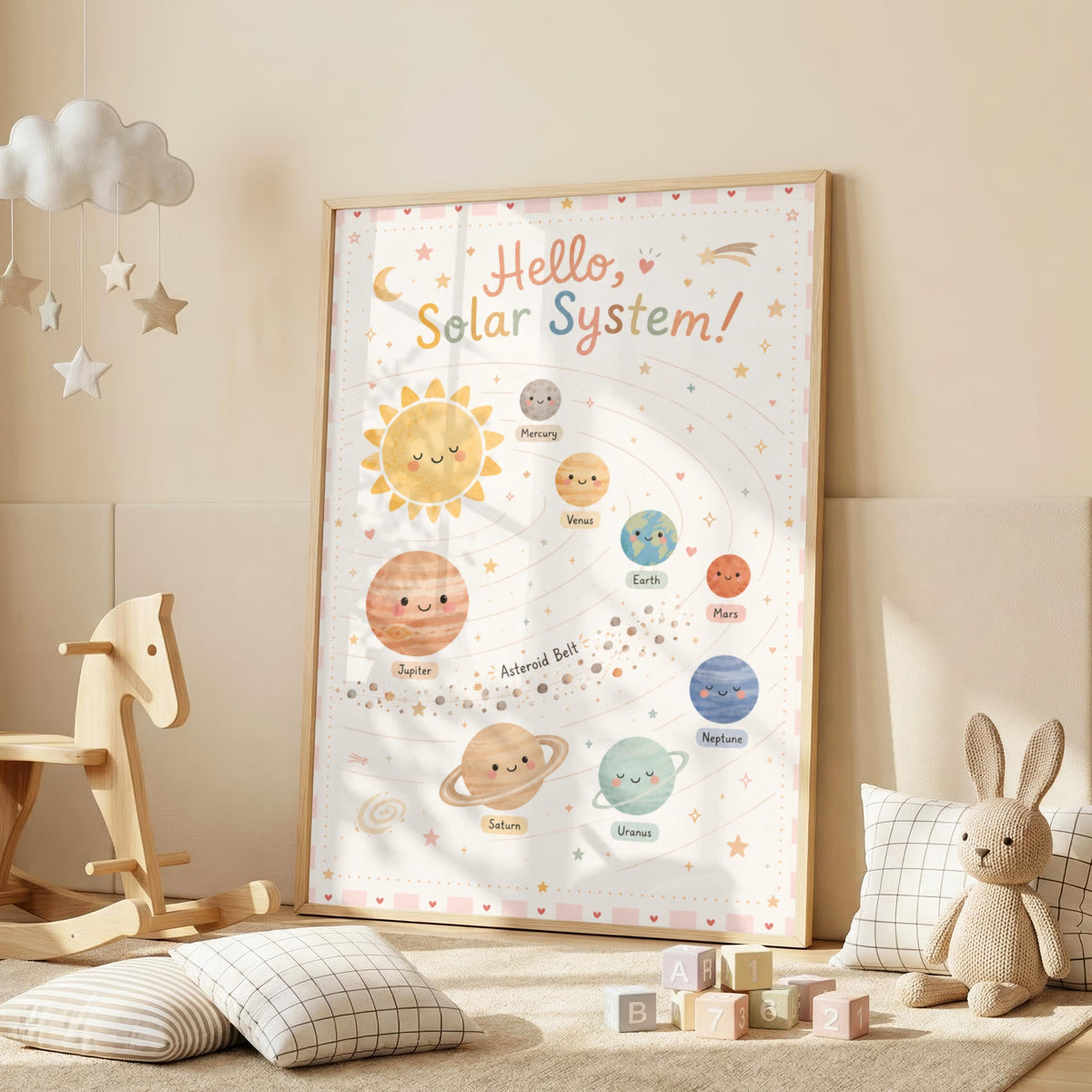 A framed pastel solar system print rests on the floor in a child bedroom next to a wooden rocking horse, toy blocks, and a stuffed rabbit.