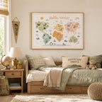 Hello World children’s world map print displayed above a cosy wooden bed in an adventure-themed child’s bedroom, styled with green bedding, globe, teddy bear, travel books, backpack, neutral decor and warm natural light.