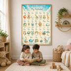 A young boy and girl sit on a white rug reading a book together in front of a large framed alphabet print mounted on the wall.