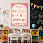 A framed pink alphabet poster is displayed on a wall between child art and a chalkboard with colorful bunting.
