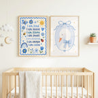 Two framed prints hang above a wooden baby crib; one features blue affirmations and the other shows a swan illustration.