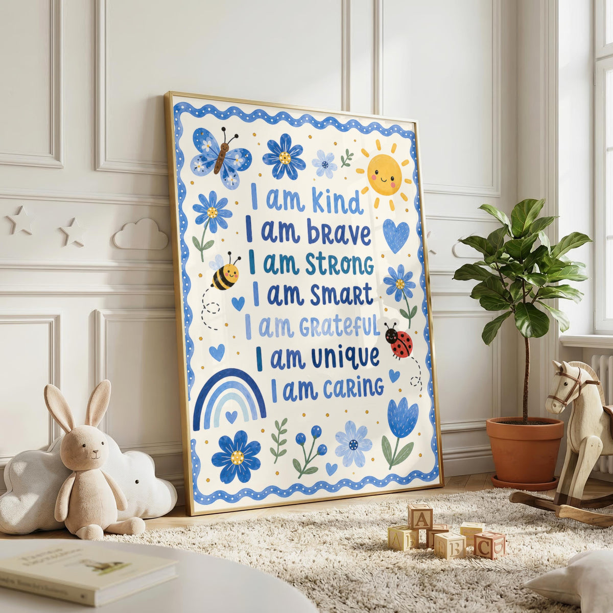 An affirmation print in a wooden frame hangs on a white wall above a wooden chest of drawers.