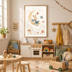 A framed watercolor print of a bunny reading on a crescent moon hangs above a wooden play kitchen in a child room.