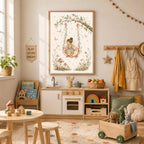 A framed watercolor art print showing a fairy on a flower swing, displayed in a children's playroom above a wooden play kitchen.