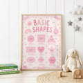 Pink educational shapes nursery print featuring smiling circle, square, triangle, rectangle, heart, star, oval, diamond and hexagon shapes with bows, flowers and playful pink details.
