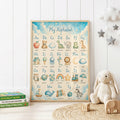 Blue educational alphabet nursery print featuring uppercase and lowercase letters A to Z with illustrated animals and objects, set against a soft blue and cream background with clouds, stars and a crescent moon.
