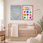Two educational posters hang on the wall above a wooden baby crib in a simply decorated nursery.