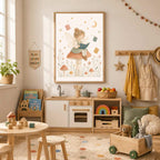 A framed watercolor print of a fairy reading a book on a mushroom hangs above a wooden play kitchen in a child room.