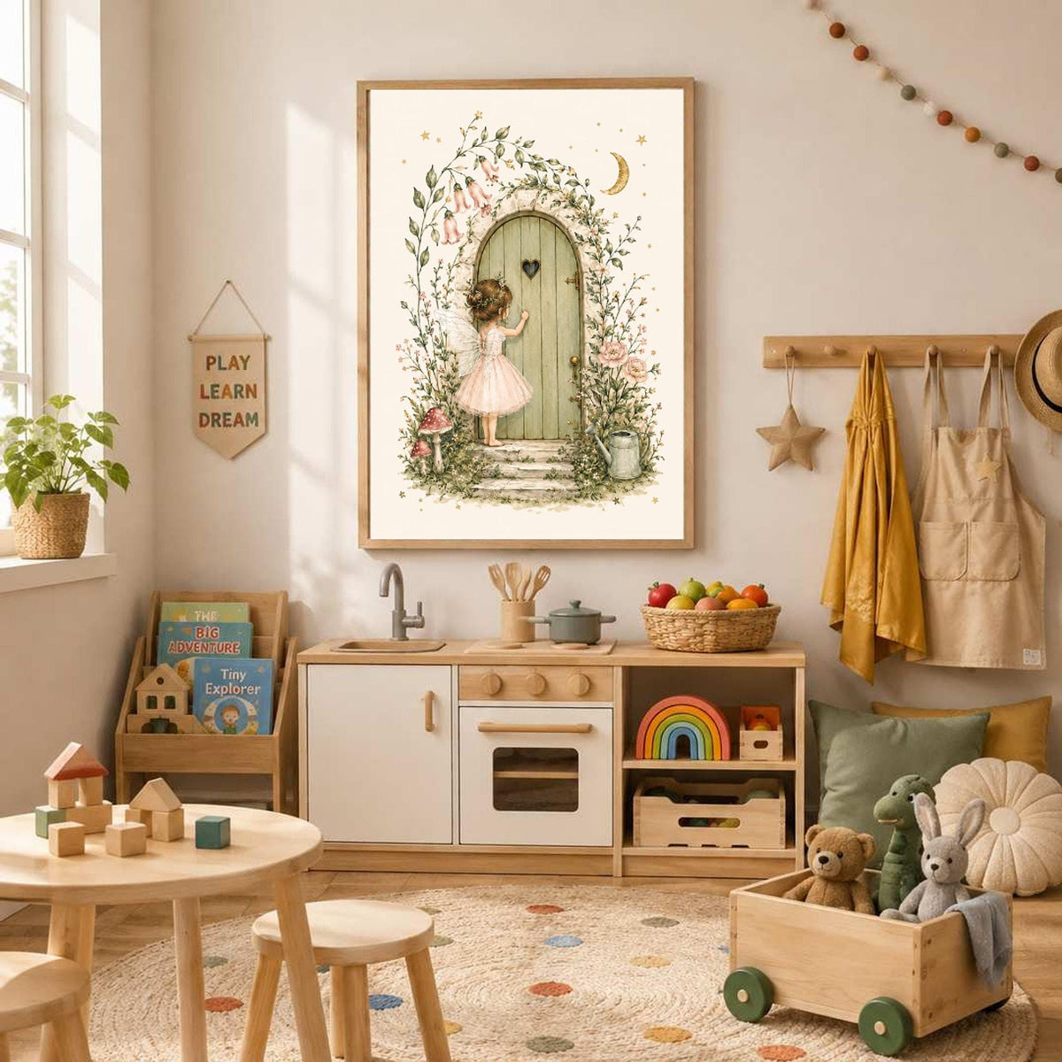 Framed watercolor print of a fairy at a garden door hanging in a children playroom with a wooden kitchen set and toys.