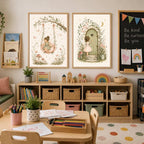 A pair of framed fairy art prints hanging above a low wooden shelving unit in a brightly lit playroom or classroom.